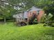 Backyard view showcases an elevated wooden deck, lush greenery, and the home's exterior at 2116 Dana Pl, Shelby, NC 28152