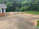 The backyard features a spacious concrete pad, surrounded by lush greenery and mature trees at 2116 Dana Pl, Shelby, NC 28152