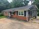 View of the exterior of a brick home with gray siding and black shutters showcasing outdoor charm at 2116 Dana Pl, Shelby, NC 28152