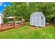 Cozy backyard features a shed and a charming wooden deck with a swing, perfect for relaxation and storage at 2490 Hawk Ridge Dr, Gastonia, NC 28056