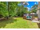 Lush backyard featuring a wooden deck, mature trees, and ample green space for outdoor enjoyment at 2490 Hawk Ridge Dr, Gastonia, NC 28056