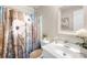 Well-lit bathroom with a shower featuring a stylish floral curtain and modern white vanity at 2490 Hawk Ridge Dr, Gastonia, NC 28056