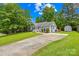 Beautiful gray house with a well-manicured lawn, long driveway, and an outdoor storage shed at 2490 Hawk Ridge Dr, Gastonia, NC 28056