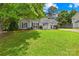 Charming single story home featuring a lush green lawn, complemented by mature trees, and black shutters at 2490 Hawk Ridge Dr, Gastonia, NC 28056