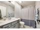 Well-lit bathroom featuring a vanity with storage, a toilet, and a shower with a patterned curtain at 3041 Winged Teal Ct, Belmont, NC 28012
