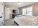 This is a cozy bedroom with a large window for natural light and a mounted television on a dark wood dresser at 3041 Winged Teal Ct, Belmont, NC 28012