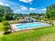 Community pool with a covered seating area, lounge chairs, and a playground nearby at 3041 Winged Teal Ct, Belmont, NC 28012