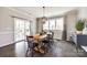 Elegant dining room featuring a rustic table, stylish lighting, and sliding door access to the patio at 3041 Winged Teal Ct, Belmont, NC 28012