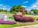 Community entrance sign with colorful flowerbed landscaping and a beautiful blue sky at 3041 Winged Teal Ct, Belmont, NC 28012