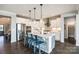 Beautiful white kitchen features a large island with quartz countertop and modern lighting at 3041 Winged Teal Ct, Belmont, NC 28012