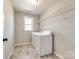 Efficient laundry room with washer, dryer, shelving, and tile flooring at 3041 Winged Teal Ct, Belmont, NC 28012