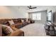 Spacious living room featuring a large, comfortable brown leather sectional and a ceiling fan at 3041 Winged Teal Ct, Belmont, NC 28012