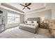 Relaxing main bedroom features a tray ceiling, a large window, and neutral tones throughout at 3041 Winged Teal Ct, Belmont, NC 28012