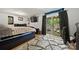 Inviting bedroom with sliding glass door to patio, with a unique area rug, and a mounted television at 3500 Colony Rd # B, Charlotte, NC 28211