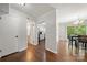 Hallway view of dining area and kitchen showcasing hardwood floors, neutral wall paint, and white trim at 3500 Colony Rd # B, Charlotte, NC 28211