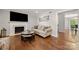Comfortable living room with fireplace, large tv, neutral sofa, hardwood floors, and access to the dining room at 3500 Colony Rd # B, Charlotte, NC 28211