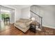 Cozy living room entrance showcasing hardwood floors, a sofa, and a staircase with gray trim at 3500 Colony Rd # B, Charlotte, NC 28211