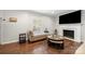 Cozy living room with hardwood floors, fireplace, a neutral colored chaise lounge, and a large television at 3500 Colony Rd # B, Charlotte, NC 28211
