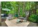 Backyard patio featuring stone tiles, a table and chairs, and umbrella, nestled amidst trees at 353 Tall Oaks Trl, Fort Mill, SC 29715