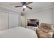 This bedroom features a ceiling fan, a TV, closet and a comfortable recliner at 353 Tall Oaks Trl, Fort Mill, SC 29715