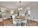 Open dining area with wood-look floors, seating for four, and a view into the living room and kitchen at 353 Tall Oaks Trl, Fort Mill, SC 29715