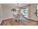 Charming dining area with wood-look floors, seating for four, and access to the outdoor patio at 353 Tall Oaks Trl, Fort Mill, SC 29715