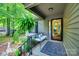 Inviting covered front porch features a cozy bench, decorative rug, and lush greenery at 353 Tall Oaks Trl, Fort Mill, SC 29715