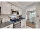 Bright, white kitchen features stainless steel appliances, tile backsplash, stone countertops, and dining nook at 353 Tall Oaks Trl, Fort Mill, SC 29715