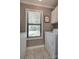 Functional laundry room with patterned wallpaper, tiled floors, and appliances near the window at 353 Tall Oaks Trl, Fort Mill, SC 29715