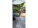 Outdoor patio area with a table, chairs, umbrella, and outdoor rug, surrounded by lush landscaping at 353 Tall Oaks Trl, Fort Mill, SC 29715