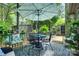 Inviting outdoor patio with patterned rug, chairs, table, and umbrella, surrounded by lush greenery at 353 Tall Oaks Trl, Fort Mill, SC 29715