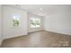Spacious bedroom featuring neutral walls, window views, and light wood floors at 5116 Izzo Ln, Charlotte, NC 28214