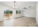 Bright living room features a sliding glass door, ceiling fan, and windows offering ample natural light at 5116 Izzo Ln, Charlotte, NC 28214