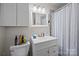 Bathroom with a white sink and vanity, white framed mirror, and white and gray shower curtain at 5640 Sharon Rd, Charlotte, NC 28210