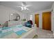 Bright bedroom with a white ceiling fan, comfortable blue chair, and large white dresser at 5640 Sharon Rd, Charlotte, NC 28210