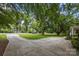 Long driveway with lush trees and yard at 5640 Sharon Rd, Charlotte, NC 28210