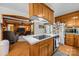 Kitchen island with range hood and cooktop open to living room at 5640 Sharon Rd, Charlotte, NC 28210