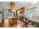 Well-lit kitchen with light wood cabinets, island cooktop, and view to dining area at 5640 Sharon Rd, Charlotte, NC 28210