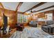 Comfortable living room featuring wood paneling, ceiling beams, and a cozy seating area at 5640 Sharon Rd, Charlotte, NC 28210