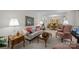 Open-concept living area boasts a patterned sofa and access to the dining room for easy entertaining at 5640 Sharon Rd, Charlotte, NC 28210