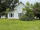 Exterior side view of the home surrounded by grass and mature trees at 65 Maynard Ave, Ansonville, NC 28170