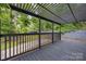 Large back deck with black railings and a pergola, offering views of the surrounding trees at 6501 Piney Path Rd, Charlotte, NC 28212