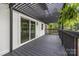 Inviting back deck featuring a black pergola and sliding glass doors to the home's interior at 6501 Piney Path Rd, Charlotte, NC 28212