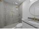 Modern bathroom featuring a glass shower with herringbone tile and gold fixtures, plus a round mirror above the vanity at 6501 Piney Path Rd, Charlotte, NC 28212