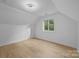 Bedroom features a modern light fixture, a window, and hardwood floors at 6501 Piney Path Rd, Charlotte, NC 28212