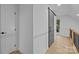 Hallway features a decorative barn door, white walls, and hardwood floors at 6501 Piney Path Rd, Charlotte, NC 28212