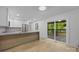 Bright, open kitchen featuring a large island, modern appliances, and sliding glass doors to the outdoor deck at 6501 Piney Path Rd, Charlotte, NC 28212