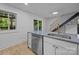 Modern kitchen with a stainless steel dishwasher, breakfast bar, and a view to a fenced back yard at 6501 Piney Path Rd, Charlotte, NC 28212