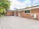 Wide shot of the home's spacious back deck with brick siding, window, and glass doors at 7416 Quail Ridge Dr, Charlotte, NC 28226
