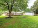 View of the home's backyard showing a deck, brick siding, a shed, and a grassy yard at 7416 Quail Ridge Dr, Charlotte, NC 28226